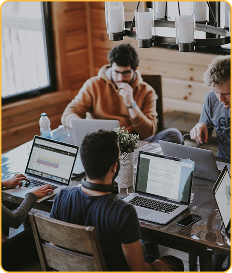 Team collaborating with laptops in a rustic office.